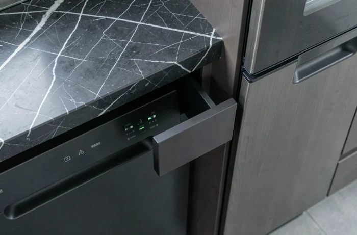 Vue rapprochée de l'espace de séparation entre un four noir et un lave-vaisselle dans une cuisine haut de gamme